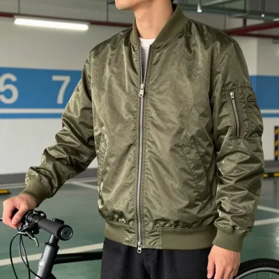 Man in Olive Bomber Jacket Holding Bike in Garage - Fashion - AI generated image