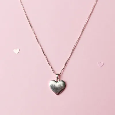 Silver Heart Pendant Necklace on Soft Pink Background - Jewelry - AI generated image