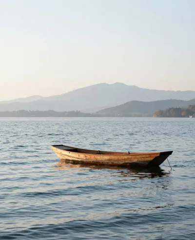 Weathered Wooden Boat Resting on Calm Lake at Sunset - Water - AI generated image