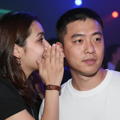 Woman Whispering to Man in White T-Shirt at Concert - People - AI generated image