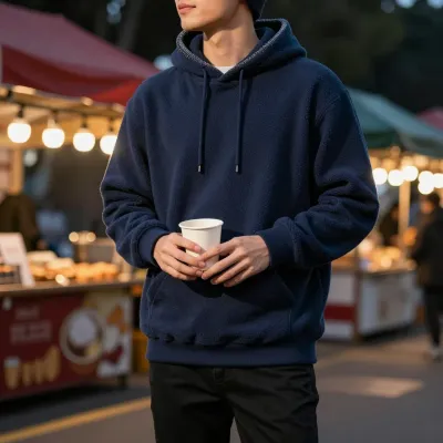 Person in Navy Hoodie Holding Paper Cup at Night Market - Fashion - AI generated image