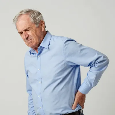 Elderly Man with Backache in Light Blue Shirt - People - AI generated image