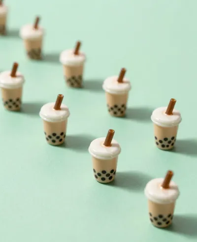 Miniature Bubble Tea Cups Arranged on Mint-Green Surface - Food - AI generated image