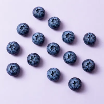 Scattered Blueberries Softly Lit on Purple Background - Food - AI generated image