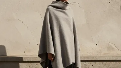 Person in Poncho Against Textured Wall - Fashion - AI generated image