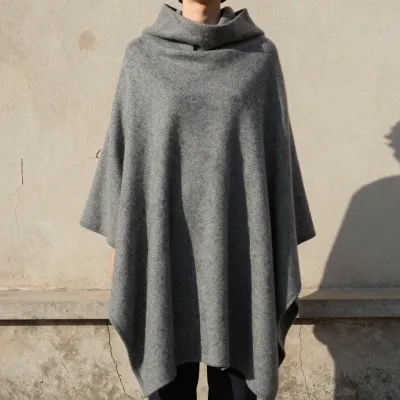 Person Wearing Gray Poncho Against Wall - Fashion - AI generated image
